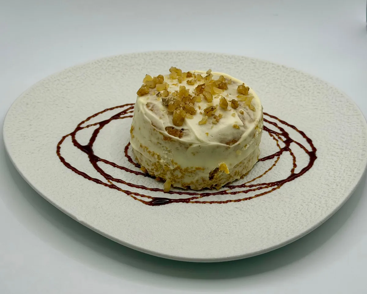 Tarta de zanahoria con nueces, emplatada con hilos de chocolate