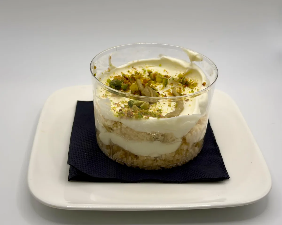 Tiramisú de pistacho servido en vaso, con crema de pistacho por encima