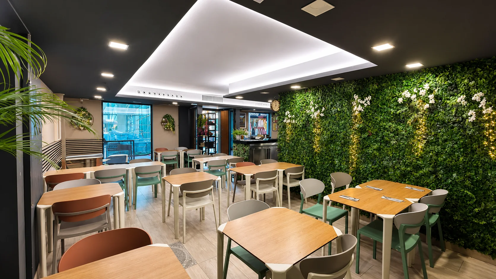 Comedor con gran pared vegetal y suelo de madera